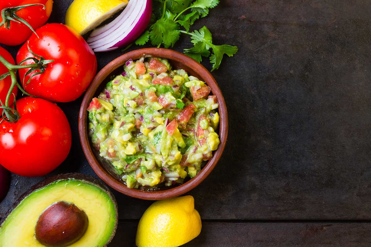 Guacamole and ingredients - avocado, tomatoes, onion, and cilantro Guacamole and ingredients - avocado, tomatoes, onion, and cilantro