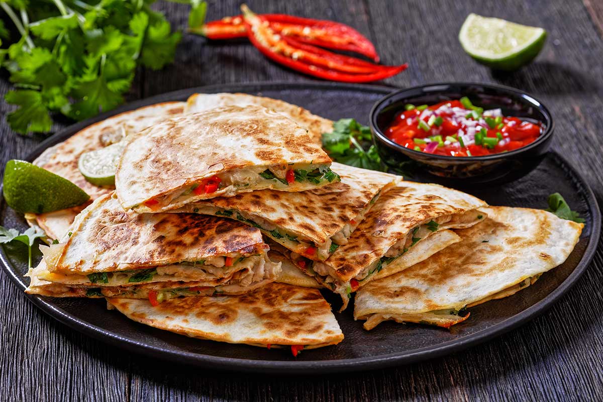 quesadilla with chicken, cheese, chilli, greens on a plate quesadilla with chicken, cheese, chilli, greens on a plate